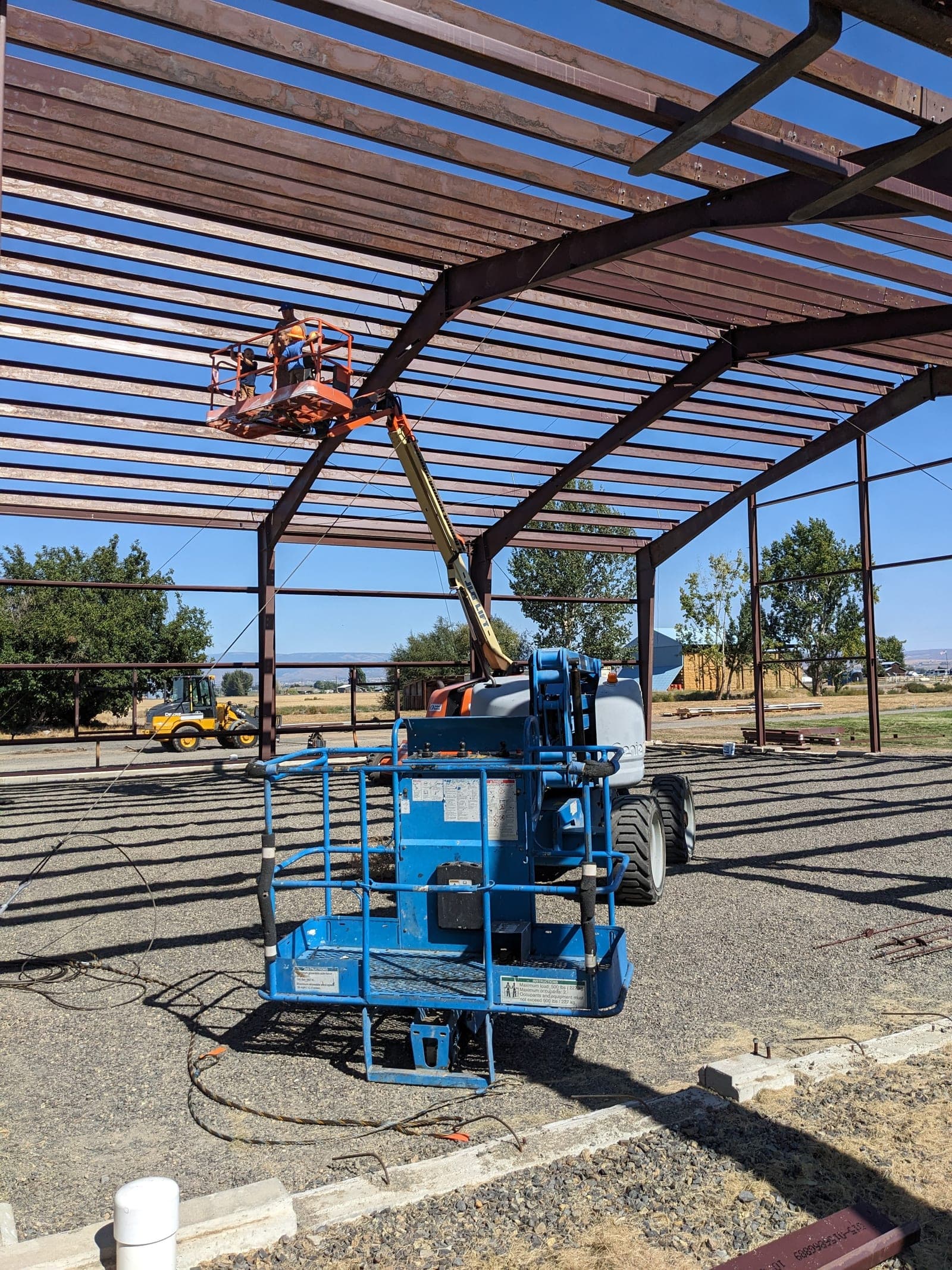 Red primary steel framing being erected for a metal building in Ellensburg, Washington
